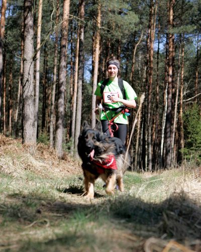 Trenerka psów z owczarkiem staroniemieckim na trasie Pucharu Polski w Dogtrekkingu.