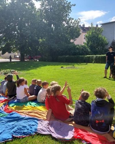 Trenerka psów z owczarkiem staroniemieckim podczas spotkania z dziećmi.